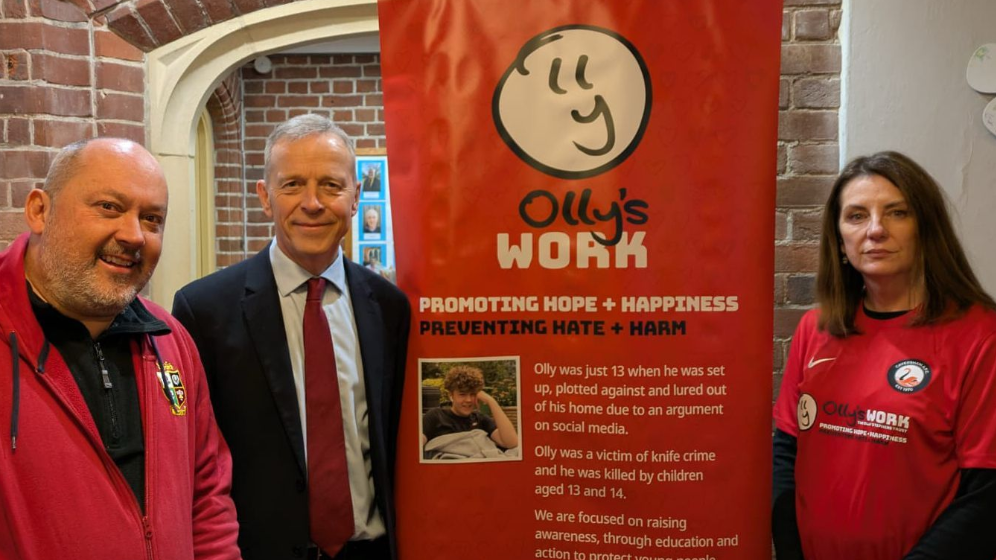 (left- right) Stuart Stephens (Olly's father) MP Matt Rodda wearing a navy suit, blue shirt and red tie and Amanda Stephens (Olly's Mum) Both Olly's parents are wearing red branded tops with the trusts name and logo.