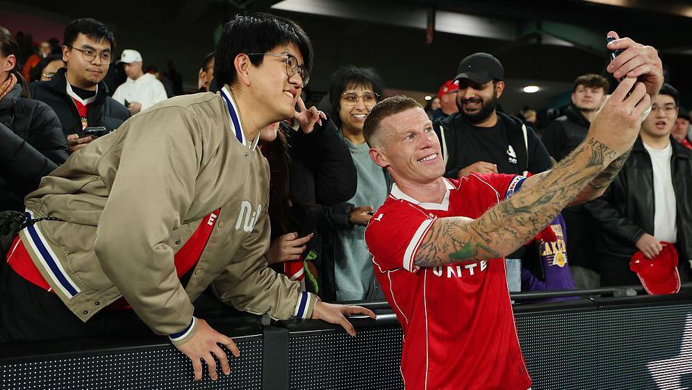 Former Wrexham player James McClean poses for a selfie with a fan