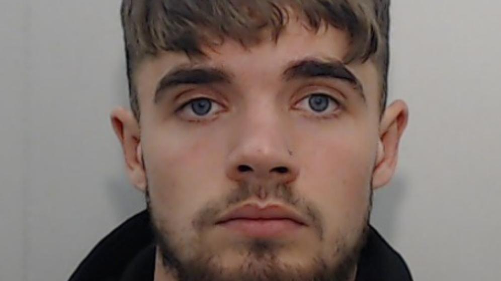 A police mugshot of 22-year-old Jack Marsden Marr. He has blue eyes, a short beard and a nose stud.