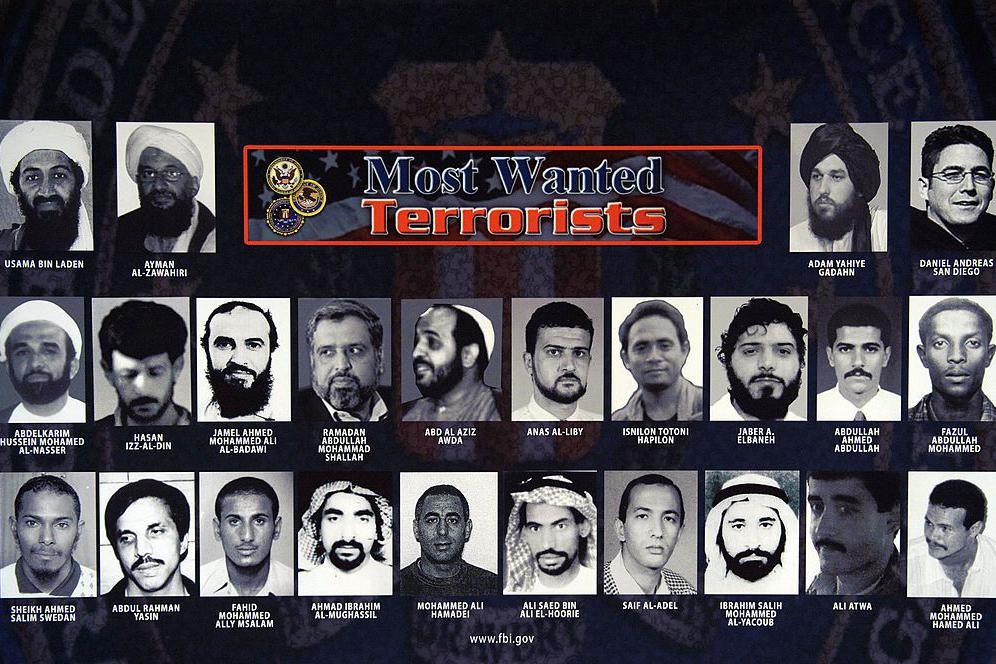 A poster of the FBI's most wanted terrorists. It is a black poster and at the top it reads "Most wanted terrorists" and there are mug shots of all the most wanted terrorists according to the FBI. Their names are underneath their images in white script.