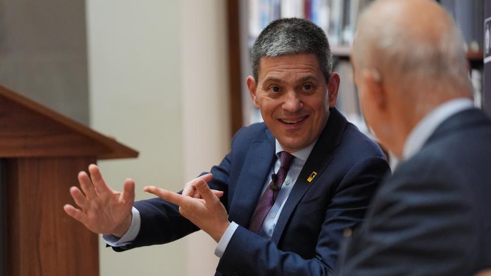 Image shows David Miliband wearing a maroon tie and blue suit, delivering a speech at RUSI in Whitehall, London, on the growing humanitarian crises in the Middle East, the emerging new global order and the potential role of 'middle powers' including the UK, on 20 May 20, 2026