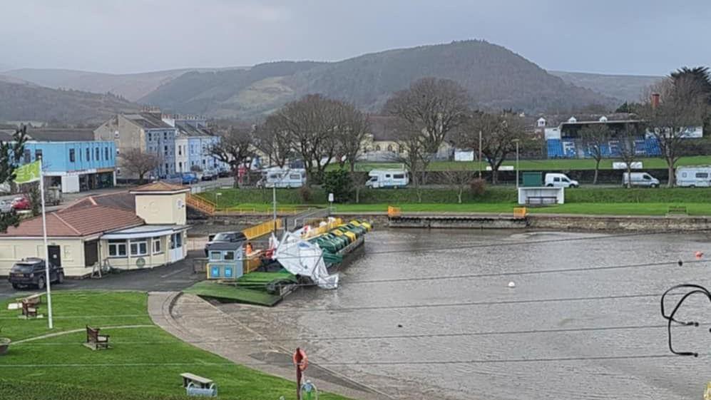 An arial view of the lake at Mooragh Park in Ramsey, you can see a large white tent like structure partially blown into the lake.