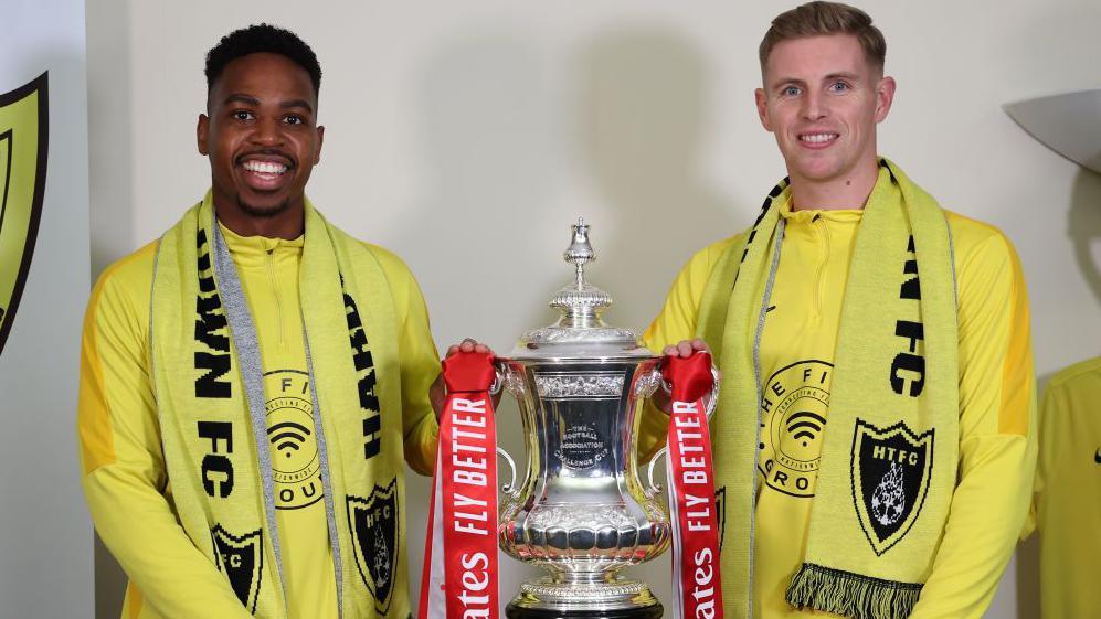 Tendai Daire and Ben Williams pictured holding the FA Cup trophy together