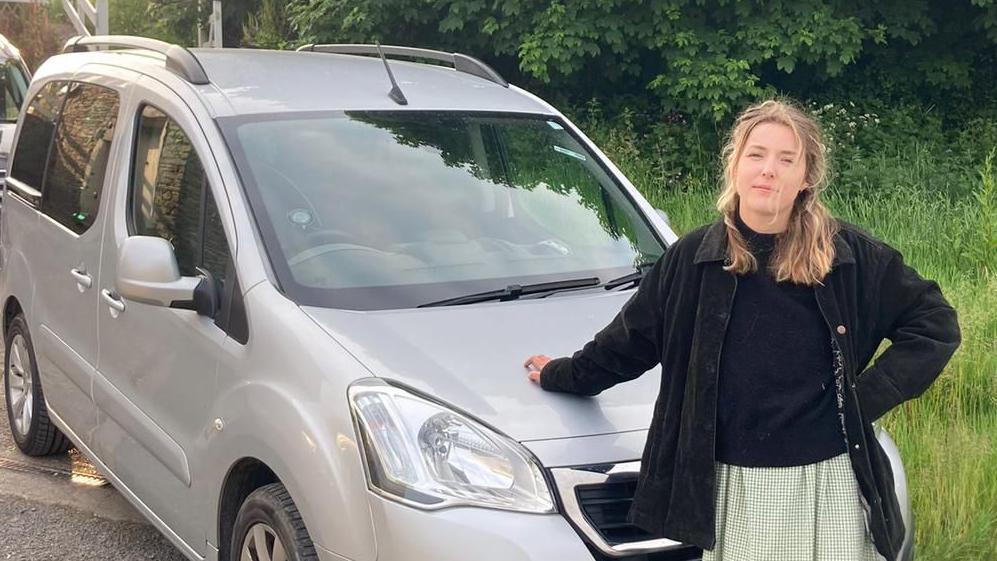 Ellie Rylands standing in front of her car 