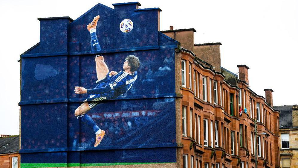 A mural showing Scott McTominay scoring an overhead kick against Denmark on Somerville Drive outside Hampden Park