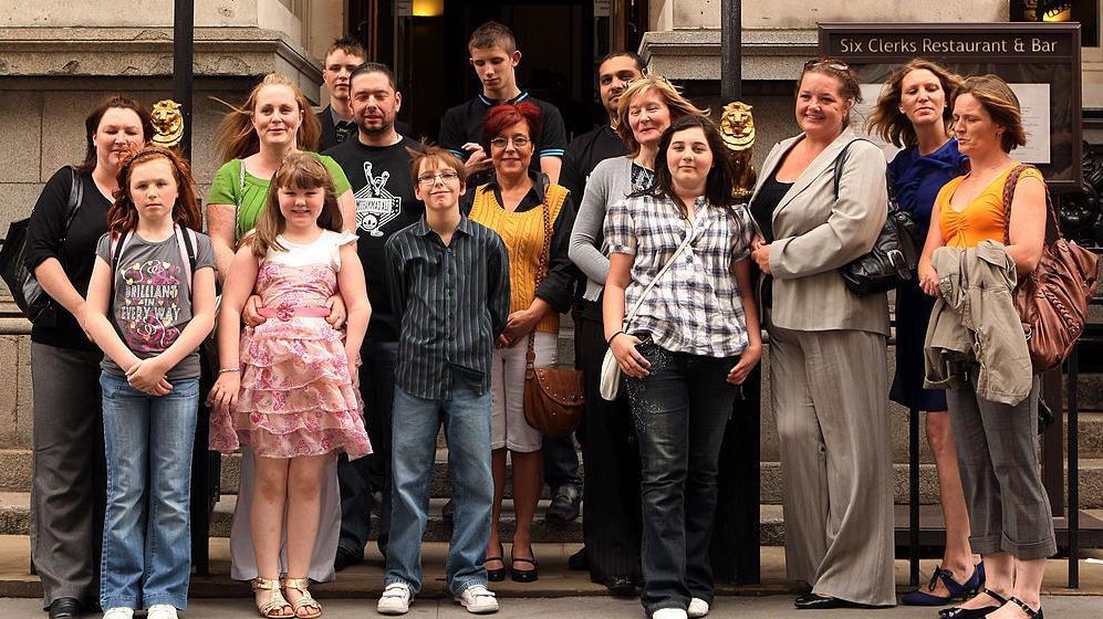 Families with children suffering from birth defects pose for photographs outside the Law Society.