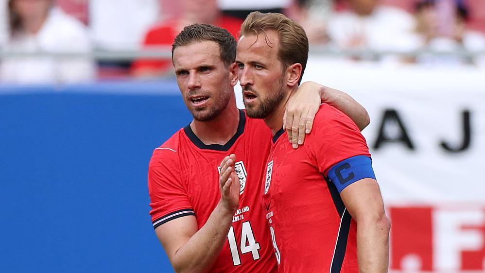 Jordan Henderson congratulates Harry Kane after the captain put England ahead against New Zealand in Tampa, with both players wearing the team's red change kit