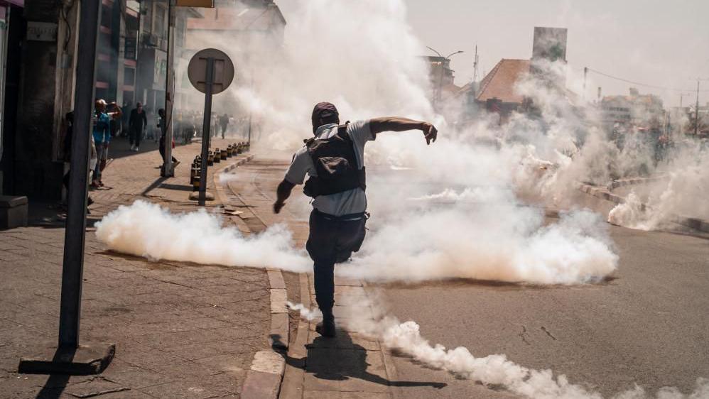 A protester kicks away a teargas cannister