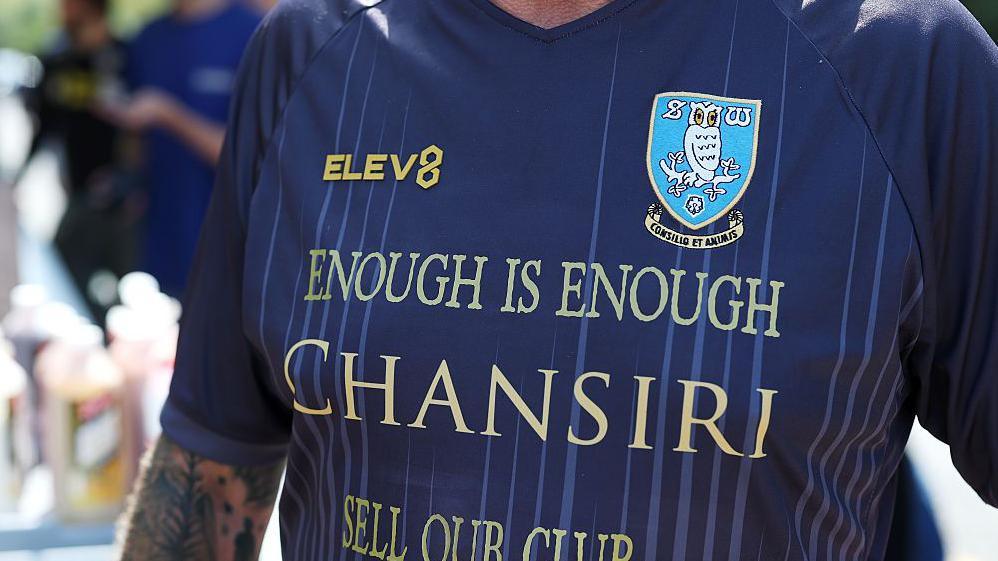 Sheffield Wednesday supporter wears a shirt protesting against the club;s owner Dejphon Chansiri