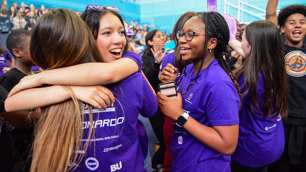 Girls hug each other in celebration at the First Tech Challenge UK Championship in Cambridge