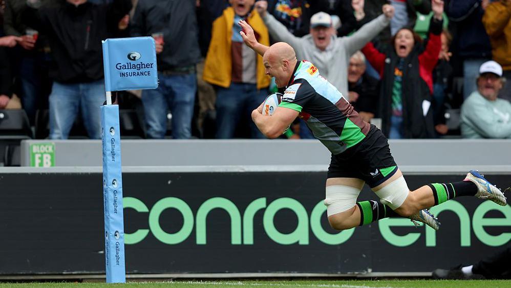 Tom Lawday raises his hand in celebration as he dives over for the winning try