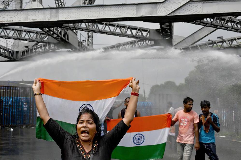 Police use water canons to disperse activists carrying India's national flag as they march towards the state secretariat demanding the resignation of Mamata Banerjee, chief minister of the country's West Bengal state amid protests against the rape and murder of a doctor near Howrah bridge in Kolkata on August 27, 2024. 