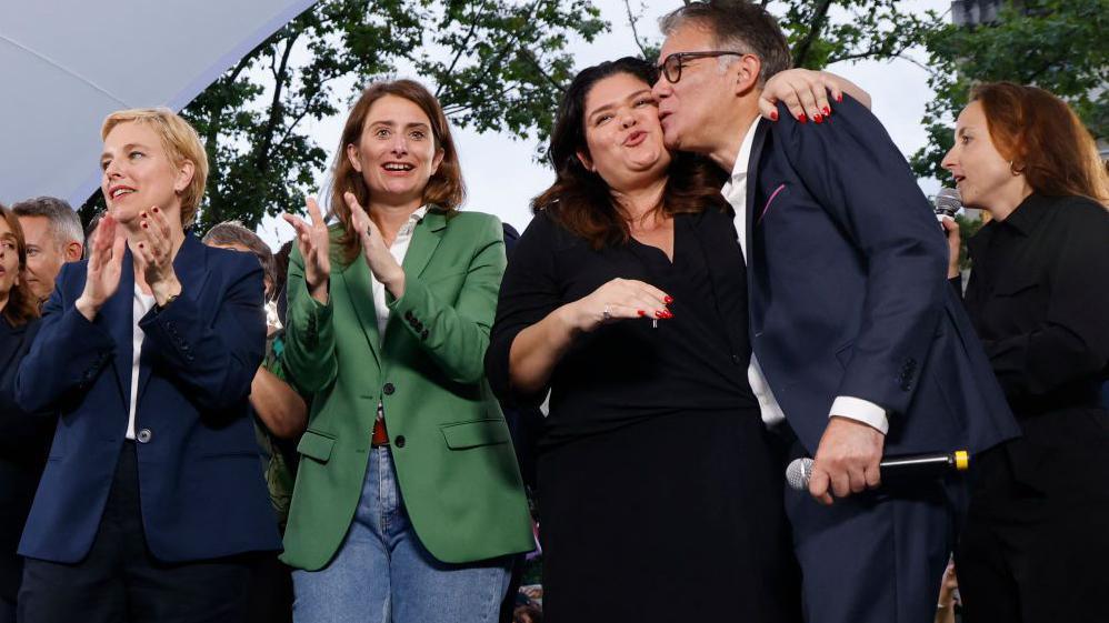 French Member of Parliament of "La France Insoumise" (LFI) group Raquel Garrido (2nd R) embraces French Socialist Party (PS) first Secretary Olivier Faure (R) as National Secretary for The Ecologists formely known as Europe-Ecologie-Les Verts (EELV) Marine Tondelier (2nd L) and French MP for La France Insoumise (LFI) and member of the NUPES leftist coalition Clémentine Autain (L) applaud