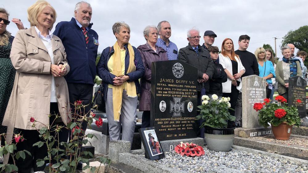 The family of the soldier gather around the grave 