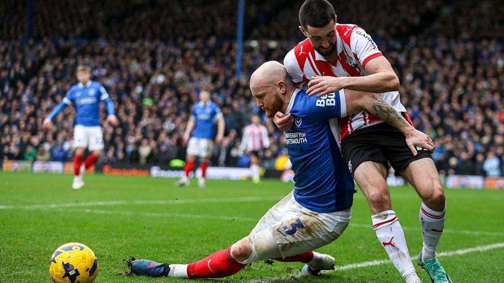 Connor Ogilvie of Portsmouth and Finn Azaz, of Southampton, tangle during the Championship derby match