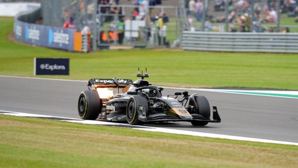 Black and gold racing care on Silverstone track