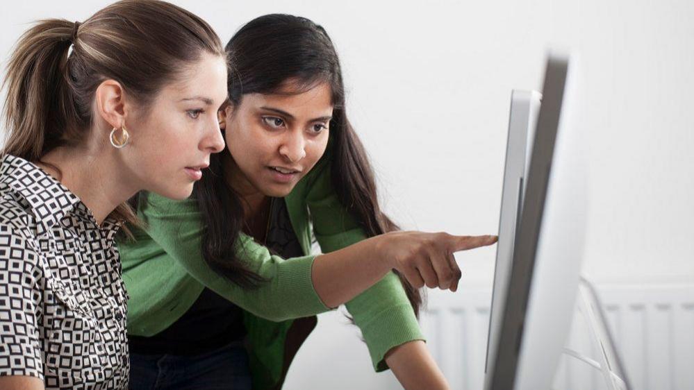 Image of two women looking at a computer screen