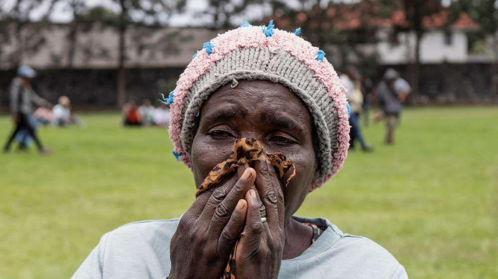 An image of a woman crying after she learnt her family member died after a boat ferrying passengers