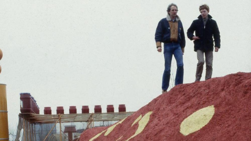 Theo Gay Anderson, aged 13, stands on top of his fibreglass dragon slide with Blue Peter presenter Simon Groom.