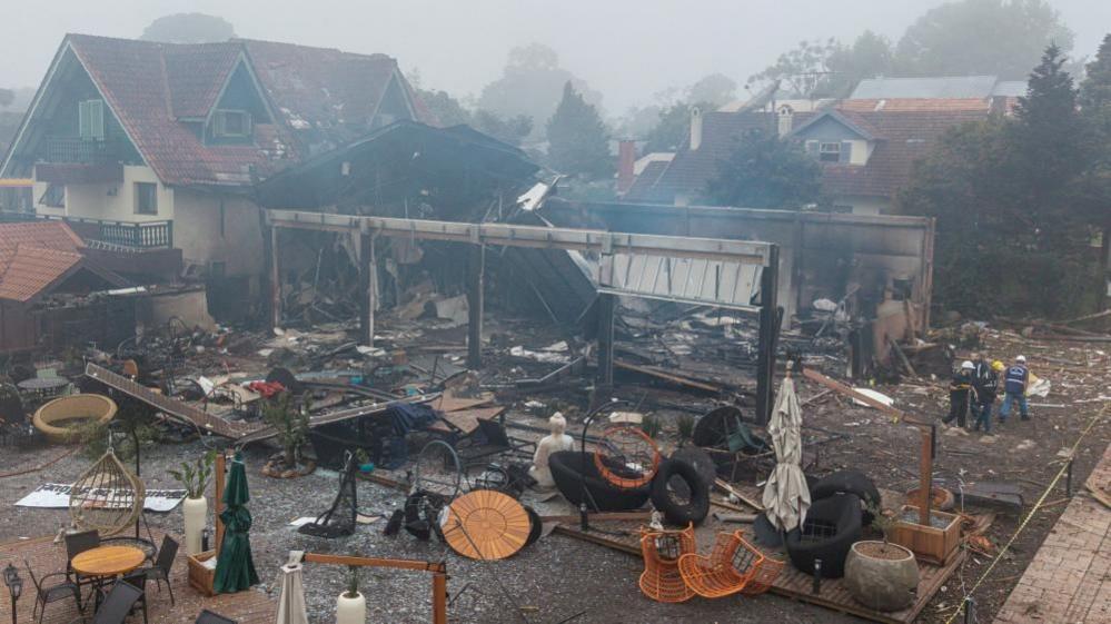 A damaged building and several wrecked tables and chairs.