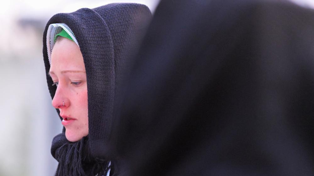 A woman dressed in traditional clothes of the Slavic ethnic minority of Sorbs, sings near the church in Schleife on Easter Sunday, eastern Germany, April 20, 2025. REUTERS/Matthias Rietschel
