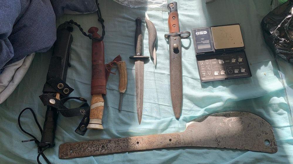 A selection of knives laid out on a sheet