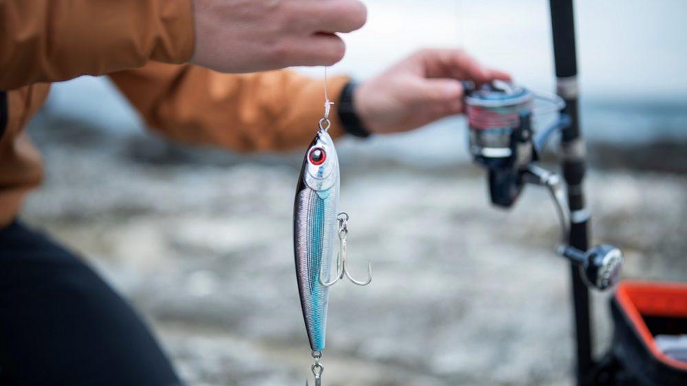 Close-up of man preparing fishing lures for shore fishing.He is getting ready for casting.