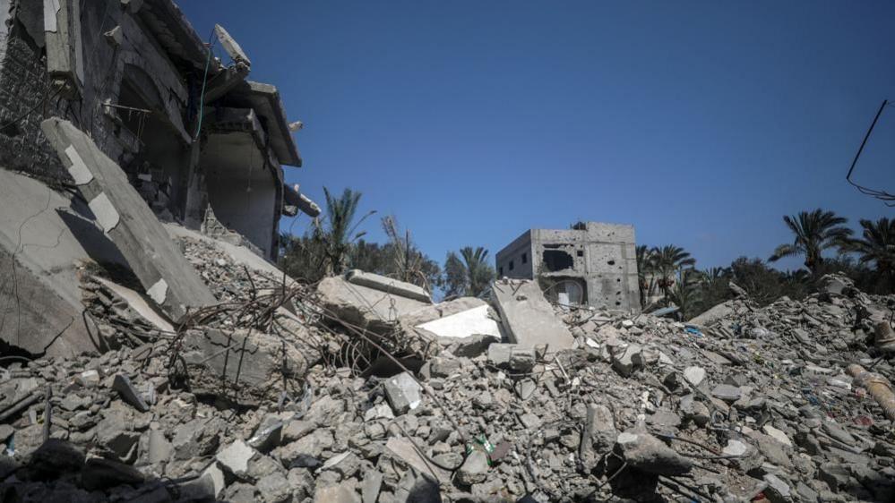 rubble of destroyed buildings against a blue sky