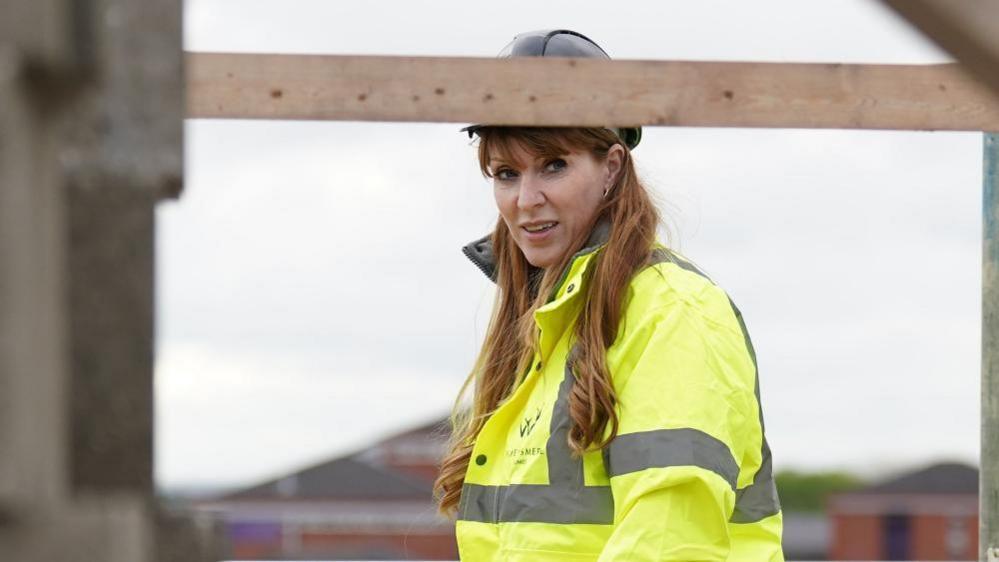 Angela Rayner pictured at a building site wearing a yellow hi-vis jacket and a black hard hat