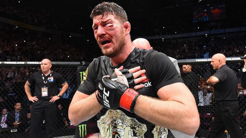 Michael Bisping is badly bruised and cut with the UFC title around his waist