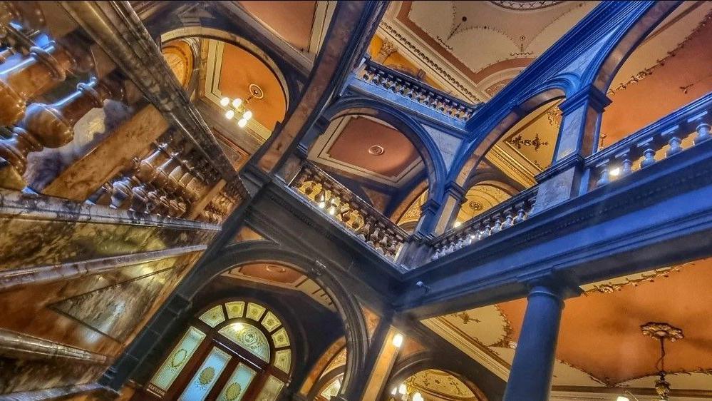 The ornate interior of the building with beautiful staircases and archways