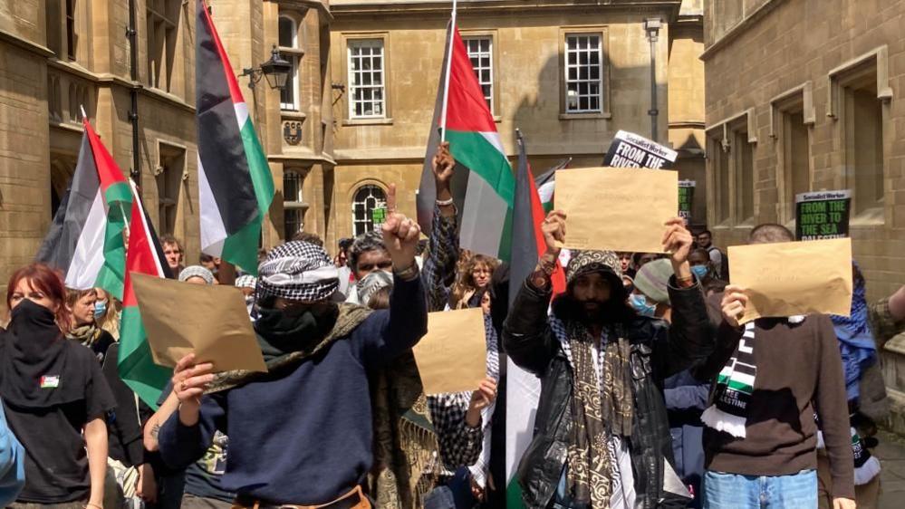 Protesters with arms and flags raised