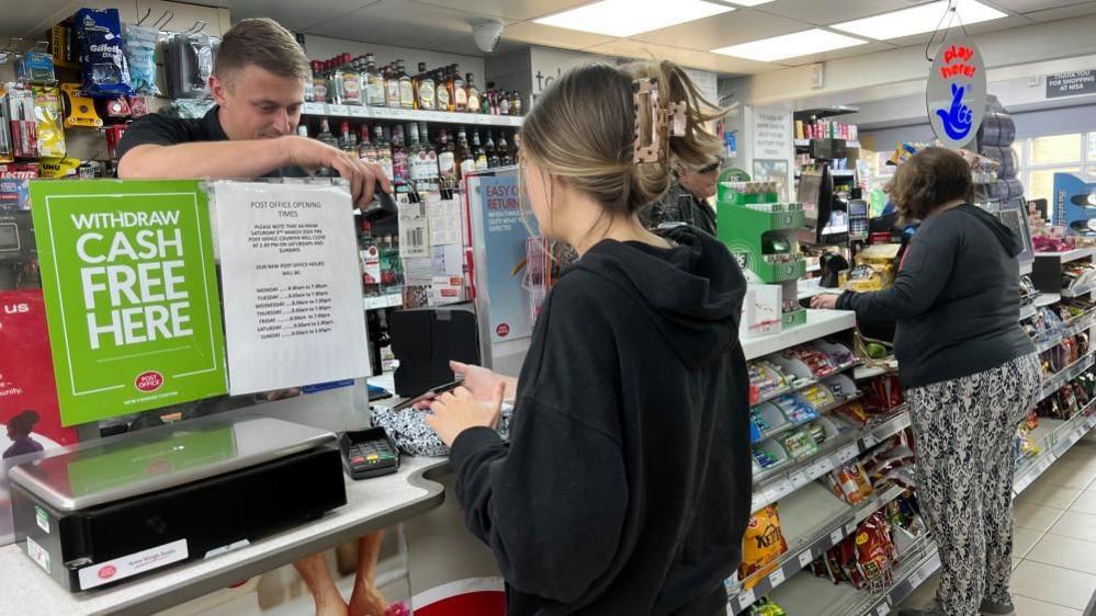 The counter at Croft Stores with two women paying for their shopping