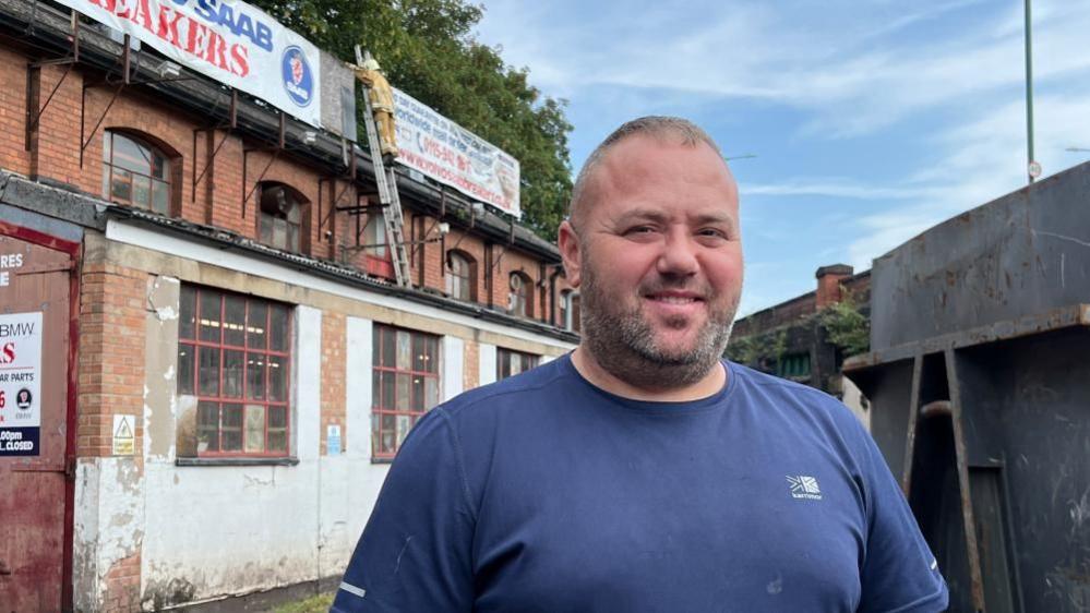 Mark Garton, from Volvo Saab Breakers, stood in the courtyard of the building where ladder man resides.