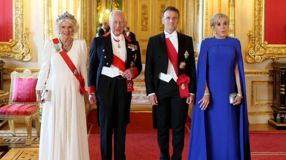 Queen Camilla, Emmanuel Macron, King Charles and Brigitte Macron stand in a line as they post for a photo at a state banquet in Windsor Castle.