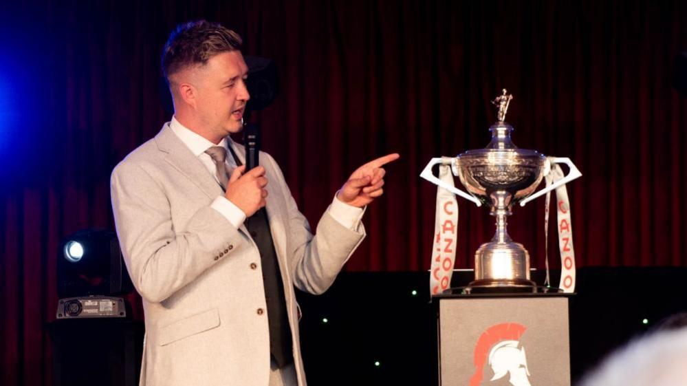 Wilson standing next to trophy