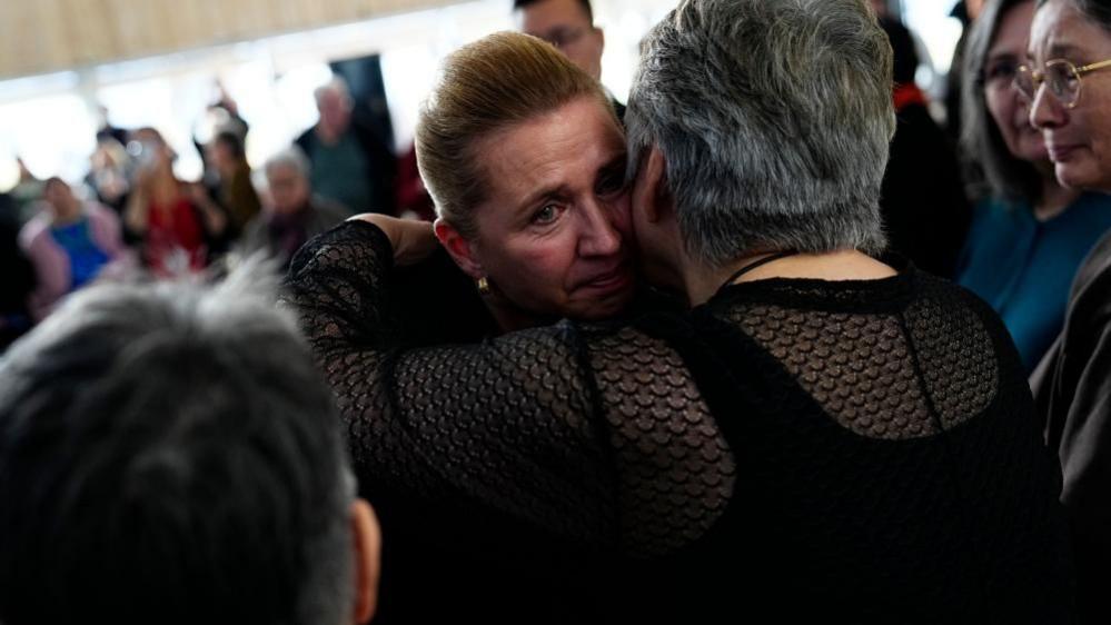 Danish Prime Minister Mette Frederiksen (C) greets and apologies to women affected by 'spiral case' after a meeting at the cutural house Katuaq in Nuuk, Greenland, 24 September 2025.
