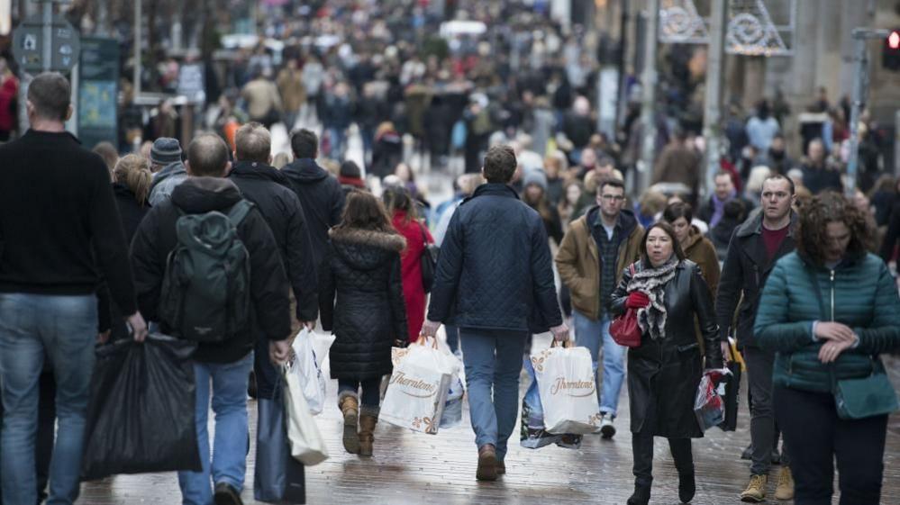 A busy street full of shoppers. 