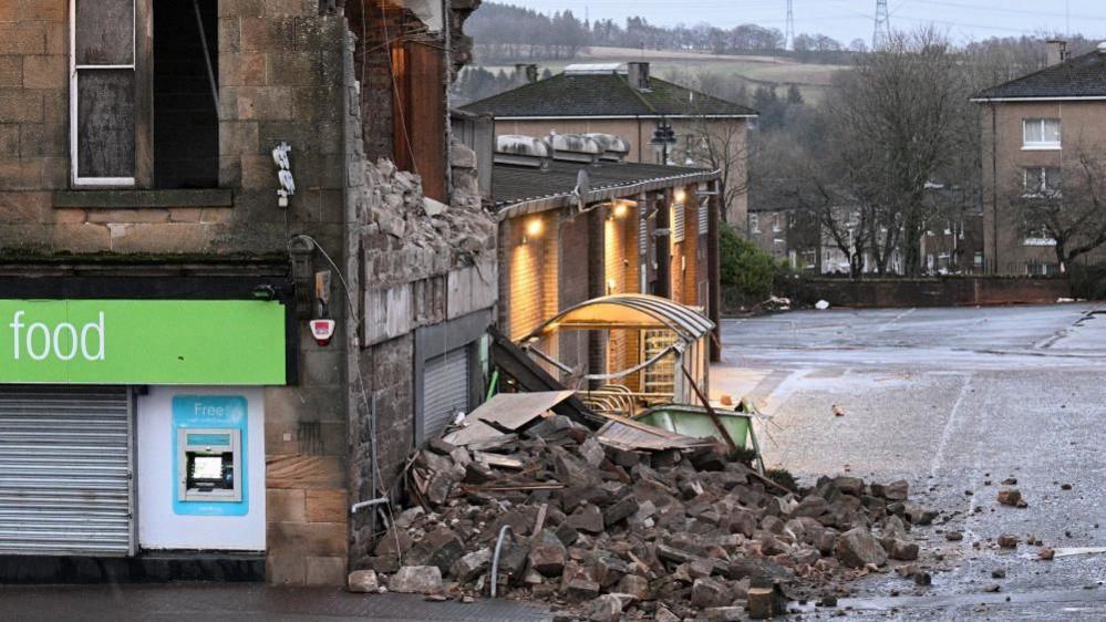 Rubble from the partially collapsed wall of a supermarket after Storm Éowyn hit the Scottish town of Denny