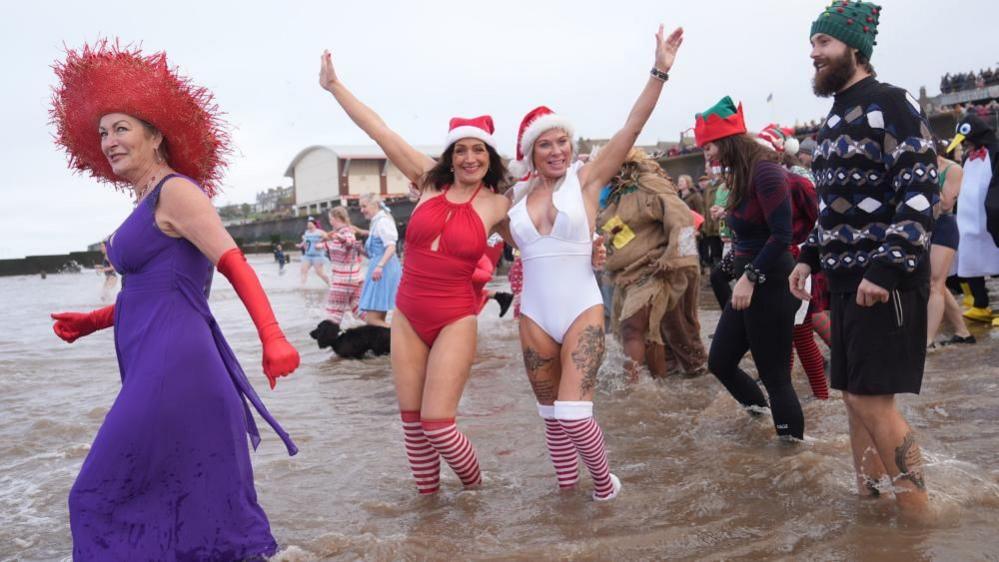 People in fancy dress cheer for the camera