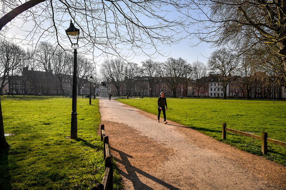 A lone person walks through Queens Square, Bristol