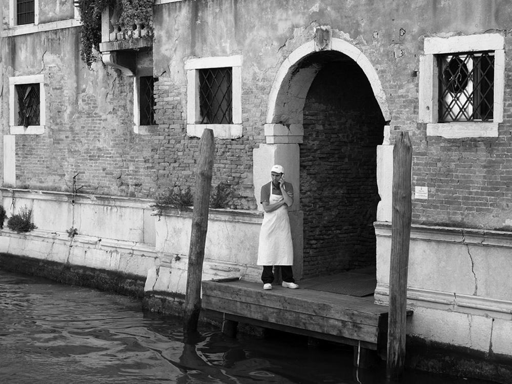 A cook on a phonecall near a canal