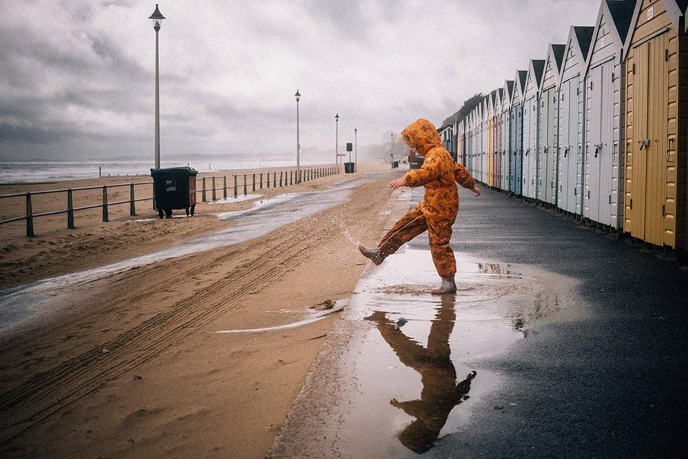 Girl kicking water in a puddle