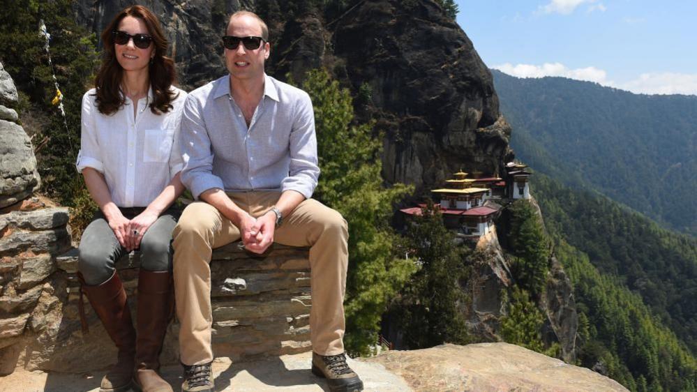 Duke and Duchess of Cambridge sitting on steps wearing subglasses