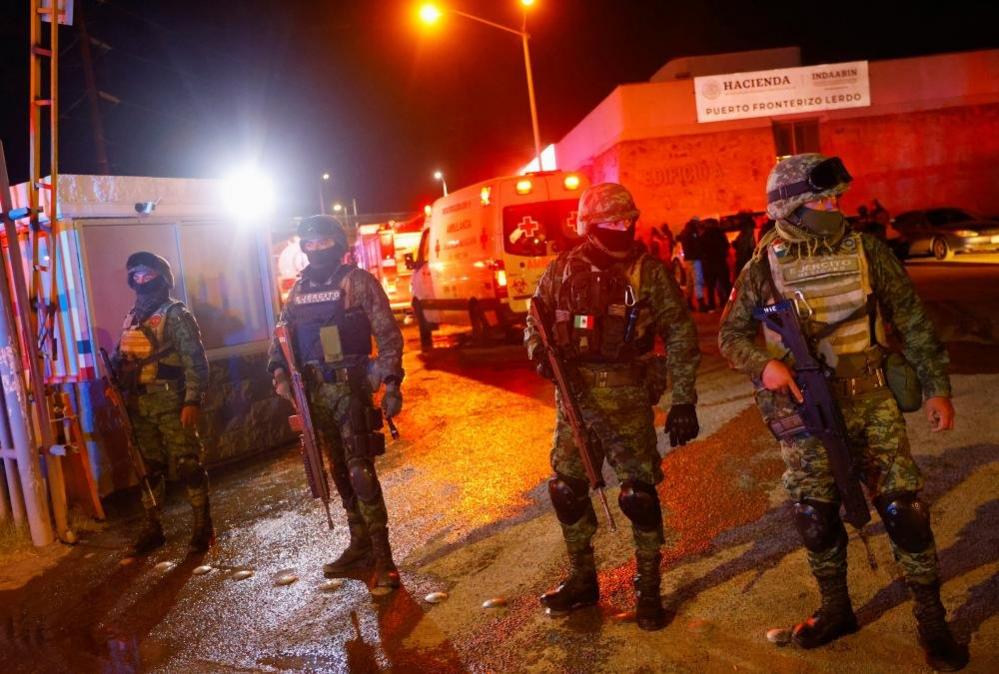 Soldiers keep watch at the entrance of a migrant detention centre, after a fire broke out leaving several casualties, in Ciudad Juarez, Mexico March 27, 2023.