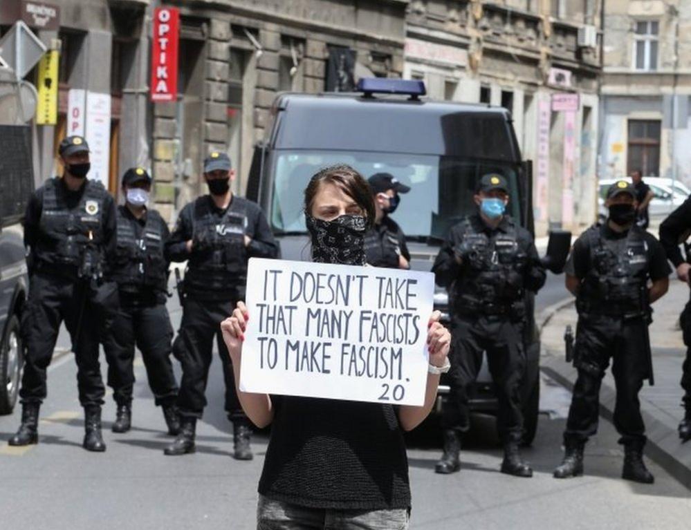 A protester in front of police in Sarajevo holds a placard that reads: "It doesn't take that many fascists to make fascism". Photo: 16 May 2020