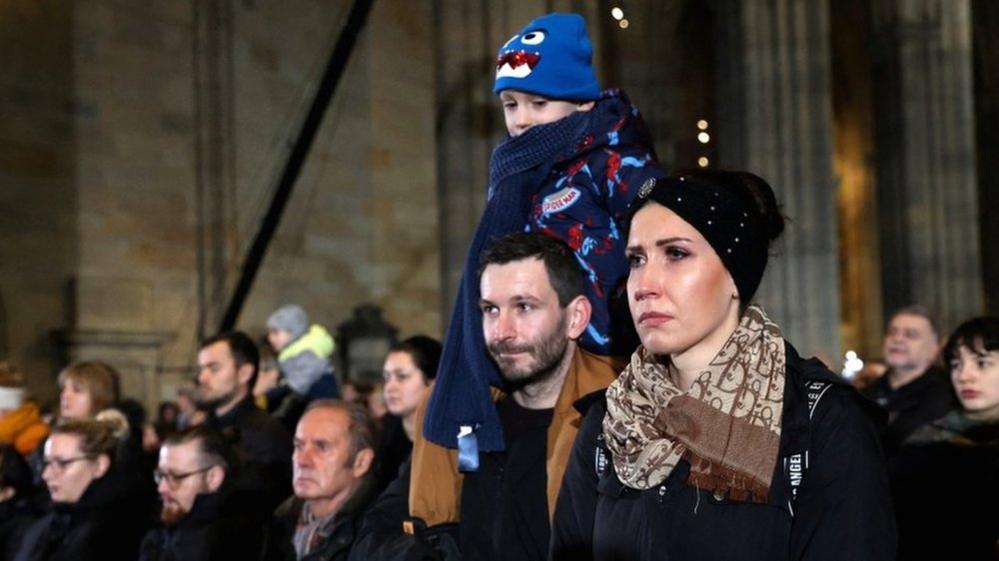 Woman at St Vitus Cathedral in Prague commemorating shooting victims