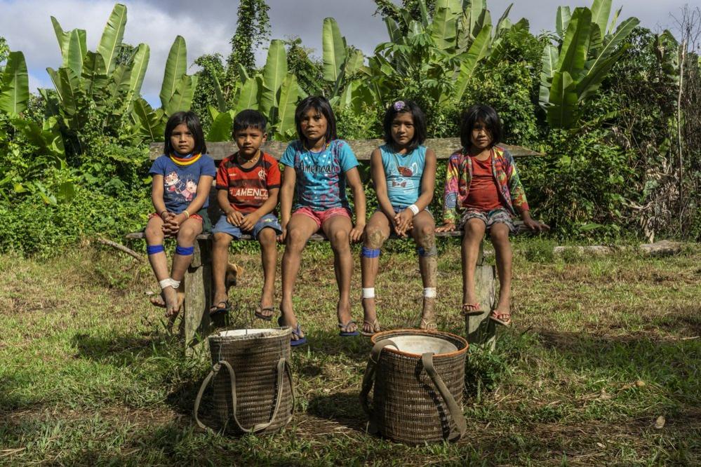 Children sit on a bench in the Waikas communituy