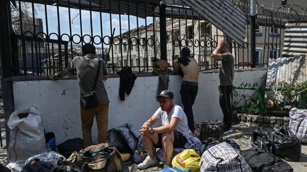 Prisoners gather at the site of the penal colony in Ukraine's southern Zaporizhzhia region that was hit by a Russian air strike. Photo: 29 July 2025