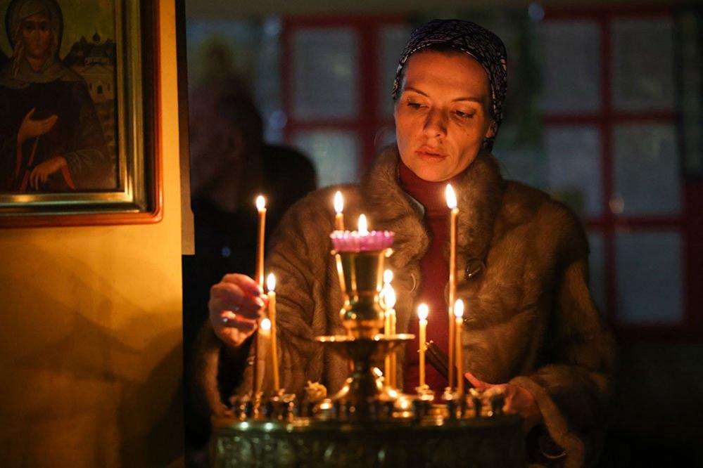 A believer takes a picture during a Christmas service at the Nativity Cathedral